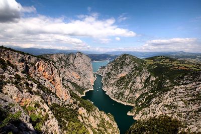 Scenic view of river amidst mountains against sky