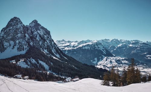 Scenic view of snow covered mountains against clear sky