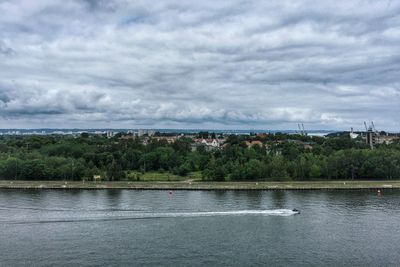 Scenic view of river against cloudy sky