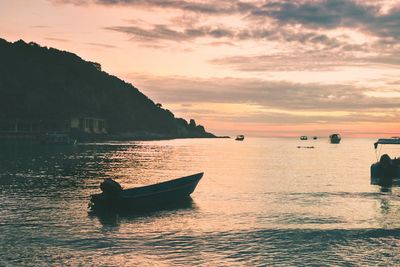 Silhouette boat in sea against sky during sunset