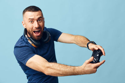 Low angle view of young man exercising against blue background