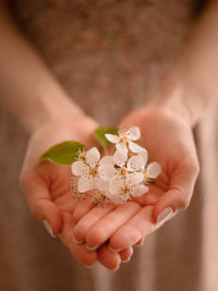 Cropped hand of bride holding flower