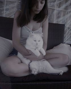 Young woman sitting with cat