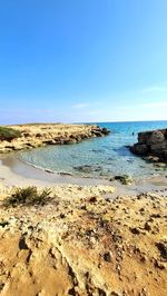 Scenic view of beach against clear blue sky