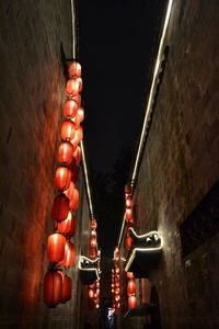 Low angle view of illuminated lanterns hanging on wall