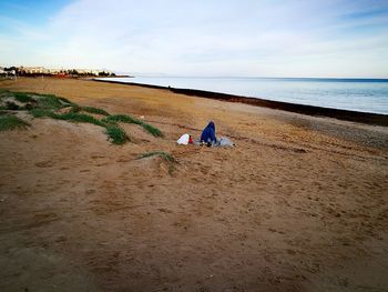 People on beach against sky