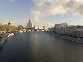 River amidst buildings in city against sky