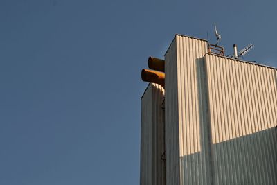 Low angle view of modern building against clear blue sky