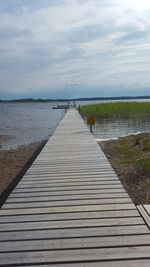 Pier over lake against sky