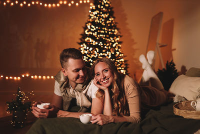 A romantic couple in love celebrates christmas holidays and new year in a cozy house at night