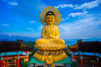 Statue against temple building against sky