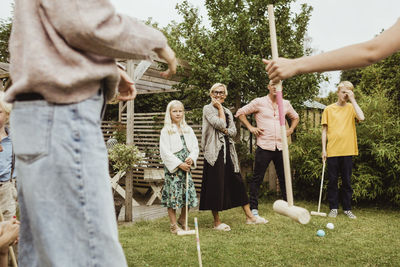 Family ready to play polo in back yard of house