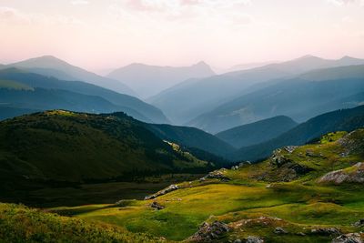 Scenic view of mountains against sky during sunrise in summer