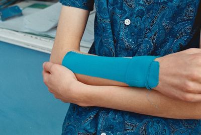 Midsection of woman standing against blue background