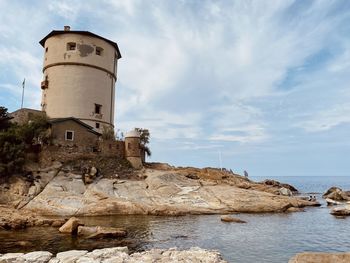 Historic building by sea against sky