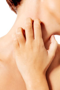 Midsection of shirtless woman scratching skin against white background