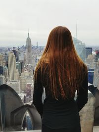 Rear view of woman standing against cityscape