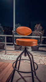 Close-up of empty chairs and table on field against sky