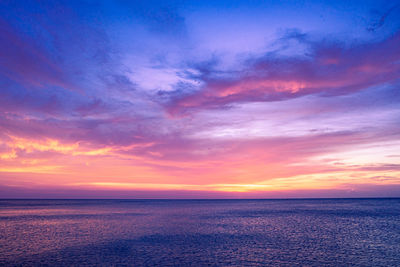 Scenic view of sea against dramatic sky during sunset