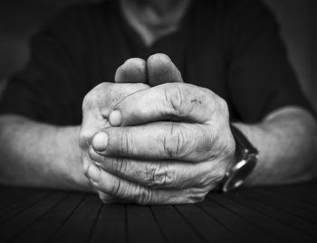 Midsection of man with hands clasped