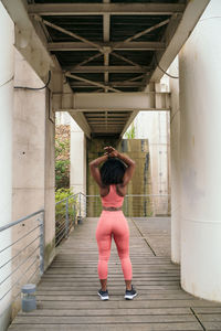 Rear view of woman stretching outdoors