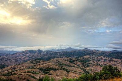 Scenic view of mountain range against cloudy sky