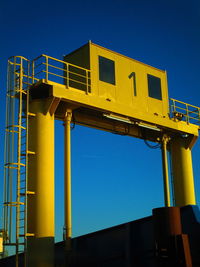 Low angle view of information sign against clear blue sky