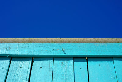 Low angle view of wooden wall against sky