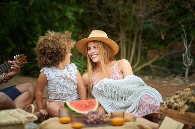 Young woman sitting on table outdoors