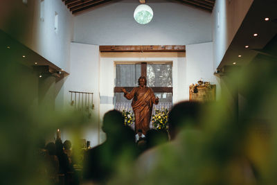 Rear view of man standing against ceiling