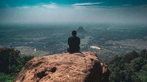 Rear view of man standing on rock