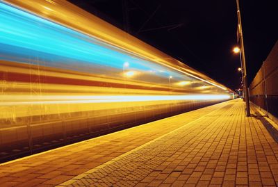 Light trails on railroad station platform at night