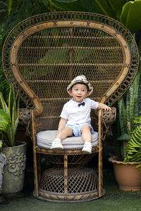 Full length of cute boy sitting on chair