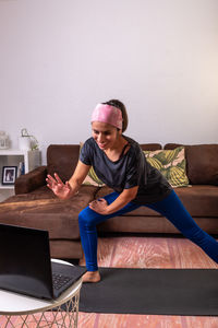 Young man using laptop while sitting on sofa at home