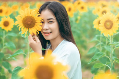 Portrait of smiling woman holding sunflower