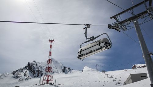 Low angle view of overhead cable cars against sky