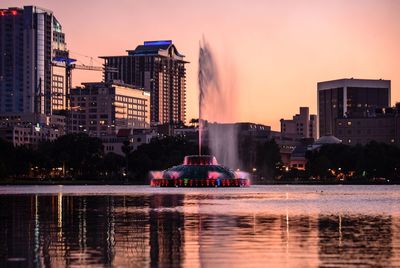 Illuminated cityscape against sky during sunset