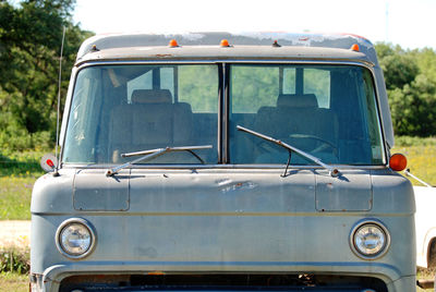 Close-up of old abandoned car on field