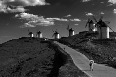 Traditional windmill on shore against sky