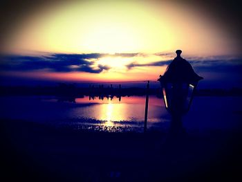 Silhouette people on beach against sky during sunset