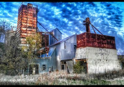 Low angle view of abandoned building against cloudy sky