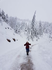 Full length of senior woman standing on snow covered mountain