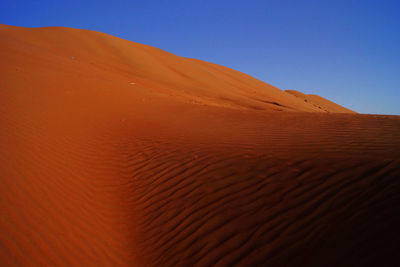 Scenic view of desert against blue sky