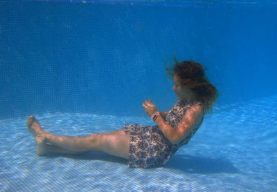 Side view of young woman swimming in pool