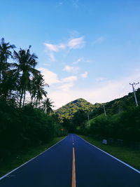 Road amidst trees against sky