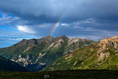 Scenic view of rainbow over mountains against sky