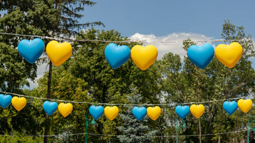 Garland in the form of yellow and blue hearts against the blue sky. 