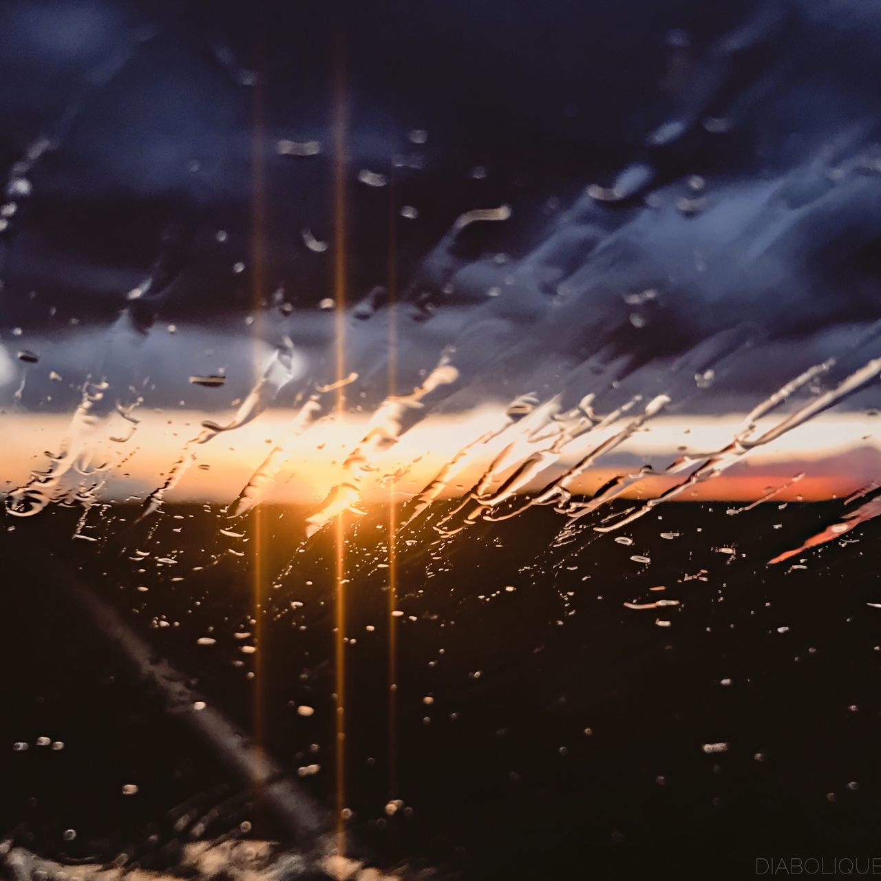 sunset, window, transparent, water, drop, wet, indoors, weather, scenics, sky, dramatic sky, beauty in nature, nature, orange color, dark, tranquil scene, glass, tranquility, focus on foreground, purity, majestic, moody sky, cloud - sky, back lit