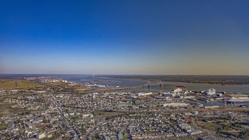 High angle view of townscape by sea against clear sky