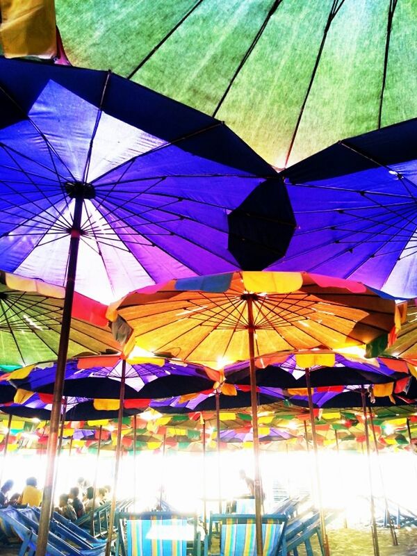 multi colored, umbrella, blue, colorful, low angle view, hanging, parasol, built structure, sunlight, flag, day, architecture, creativity, beach umbrella, pattern, decoration, fabric, art and craft, no people, outdoors